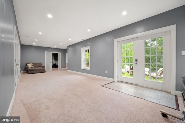 unfurnished living room featuring french doors and light colored carpet