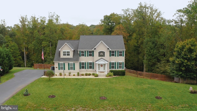 colonial-style house featuring a front yard