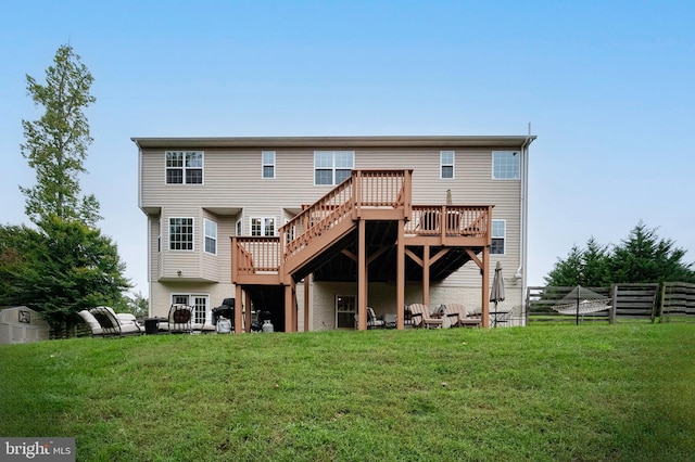 back of house featuring a wooden deck and a lawn