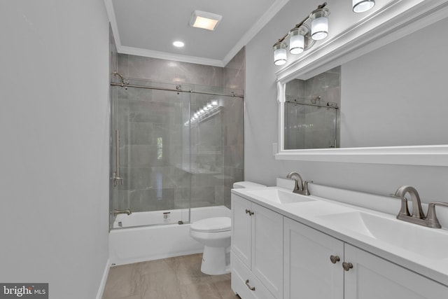 bathroom with crown molding, enclosed tub / shower combo, a sink, and toilet