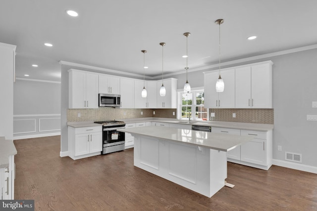 kitchen featuring visible vents, white cabinets, appliances with stainless steel finishes, a center island, and light countertops