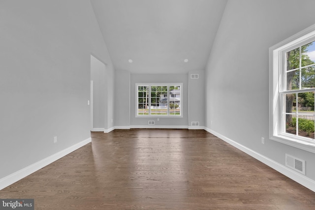 unfurnished room featuring vaulted ceiling, dark wood-style flooring, visible vents, and baseboards