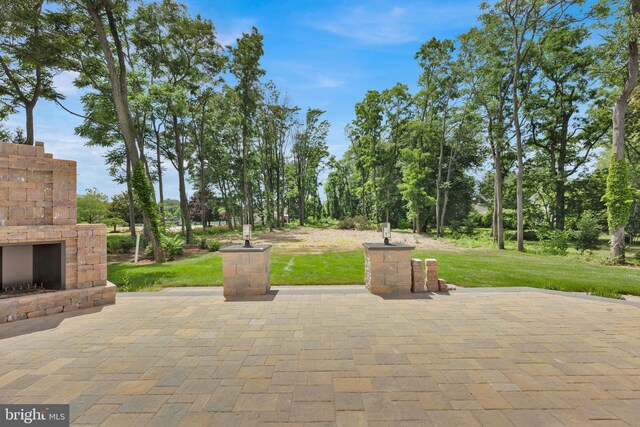 view of patio / terrace featuring an outdoor stone fireplace