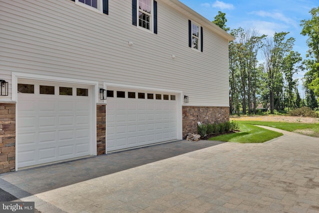 view of side of property with driveway and an attached garage