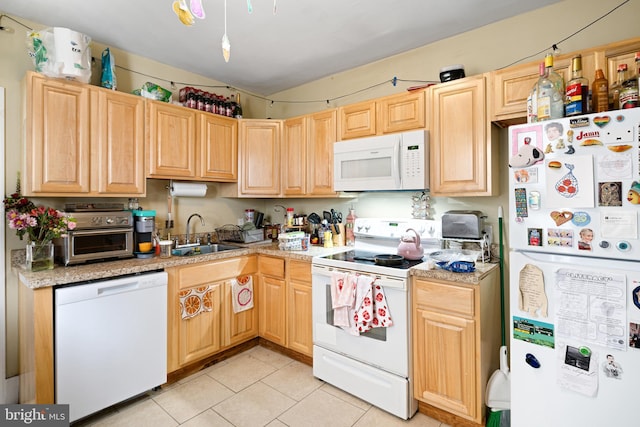 kitchen featuring white appliances, light brown cabinetry, sink, and light tile patterned floors