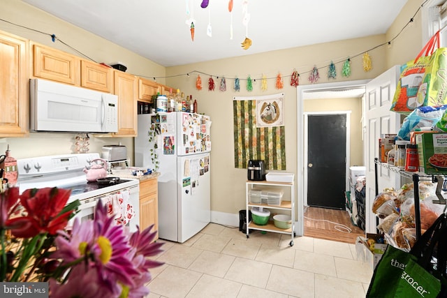 kitchen featuring white appliances, light tile patterned floors, and light brown cabinets