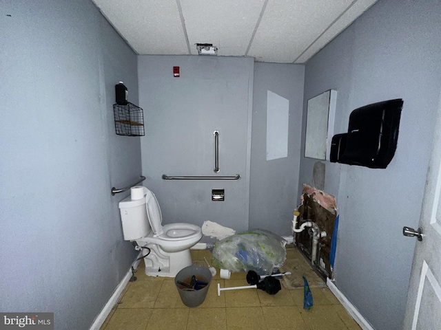 bathroom featuring a drop ceiling, tile patterned flooring, and toilet