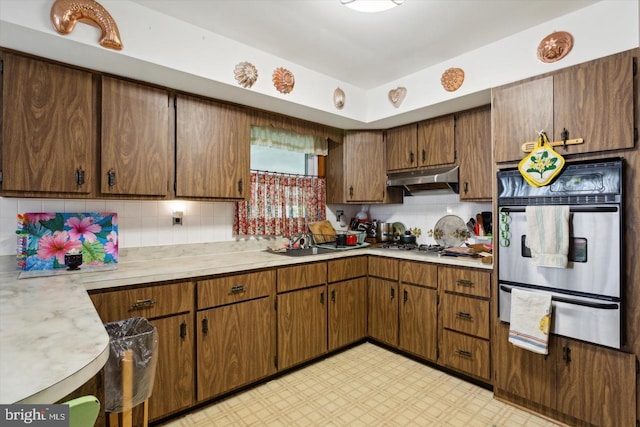 kitchen featuring tasteful backsplash, sink, and stainless steel gas stovetop