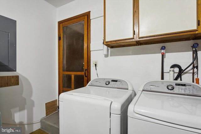 washroom with cabinets, electric panel, and washer and dryer