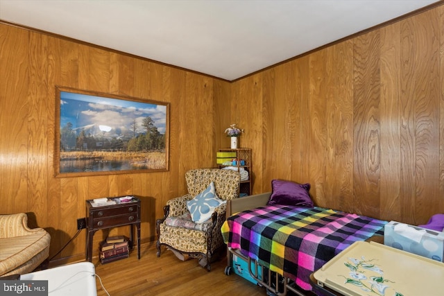 bedroom with wood-type flooring, crown molding, and wood walls