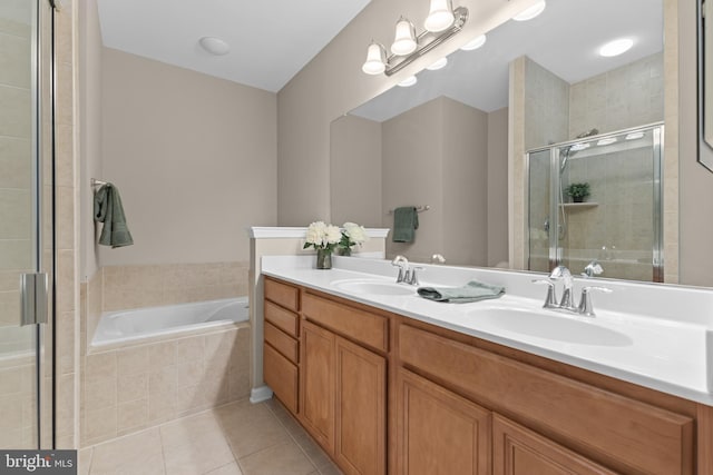 bathroom featuring tile patterned floors, a sink, a shower stall, and a bath