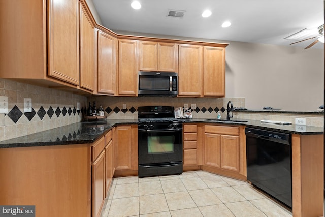 kitchen with light tile patterned flooring, a sink, visible vents, black appliances, and dark stone countertops