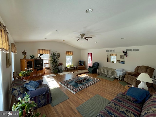 living room featuring hardwood / wood-style flooring, ceiling fan, and vaulted ceiling