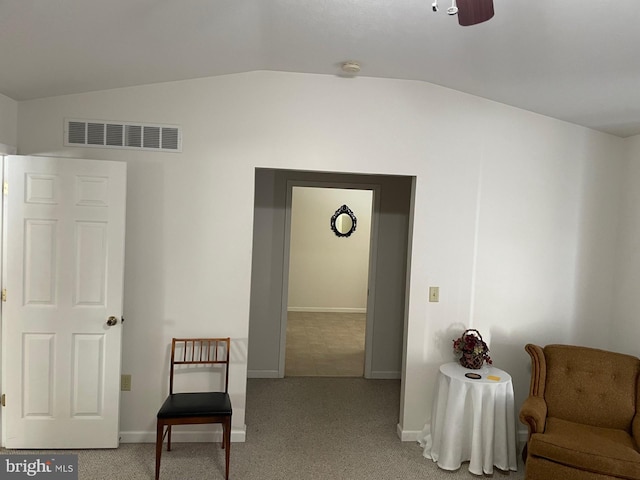 living area featuring ceiling fan, light colored carpet, and vaulted ceiling