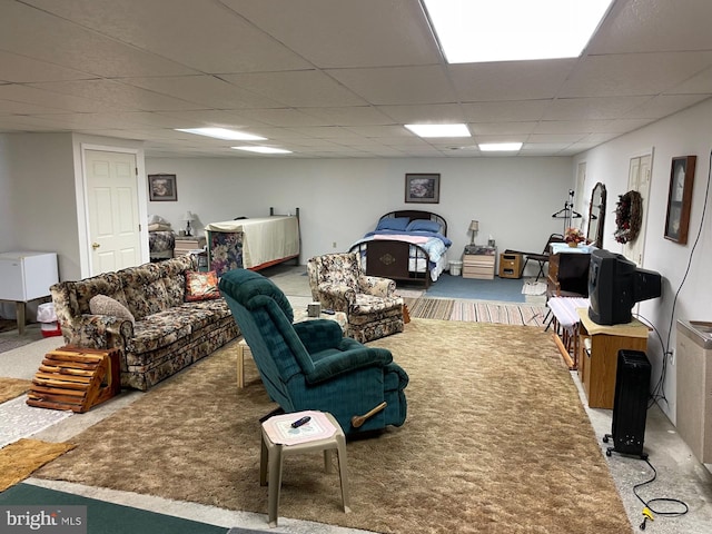 living room with a paneled ceiling and carpet