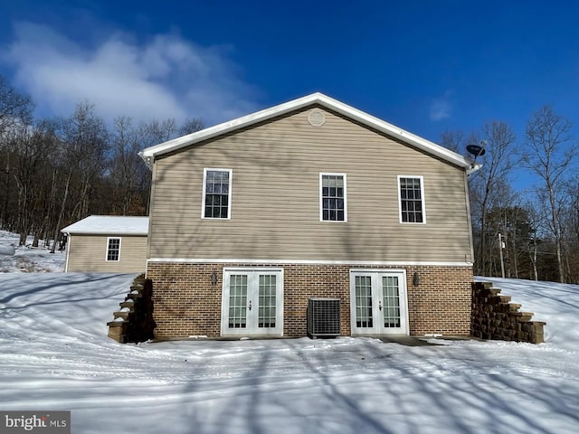 snow covered property with french doors