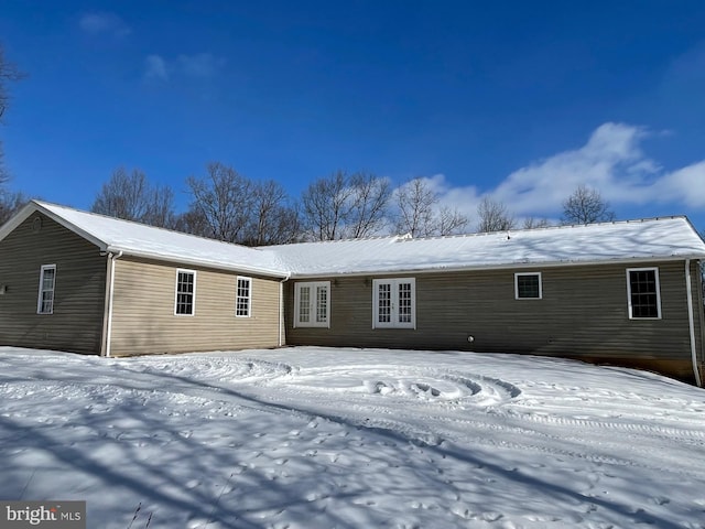 view of snow covered rear of property