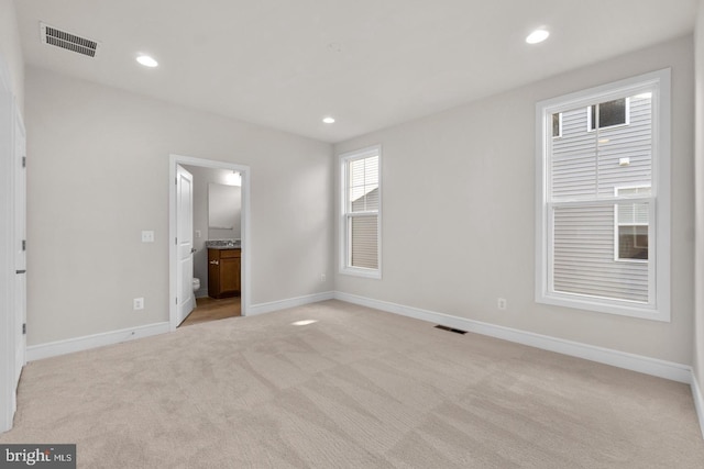 interior space with light carpet, baseboards, visible vents, and recessed lighting