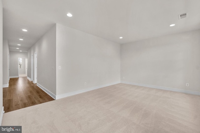 unfurnished room featuring light colored carpet, recessed lighting, visible vents, and baseboards