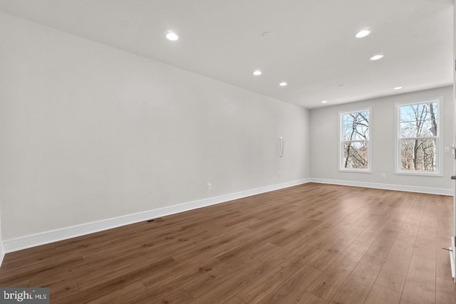 spare room with visible vents, baseboards, wood finished floors, and recessed lighting