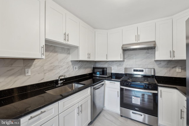 kitchen featuring dark stone countertops, sink, stainless steel appliances, and white cabinets