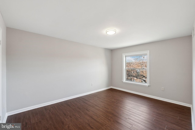 spare room featuring dark wood-type flooring