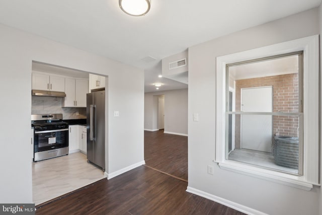 kitchen featuring backsplash, stainless steel appliances, dark hardwood / wood-style floors, and white cabinets