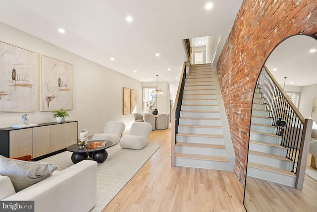 living room with brick wall and light hardwood / wood-style floors