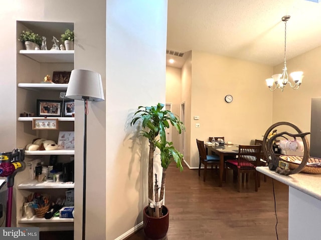 hall with dark hardwood / wood-style flooring and a notable chandelier