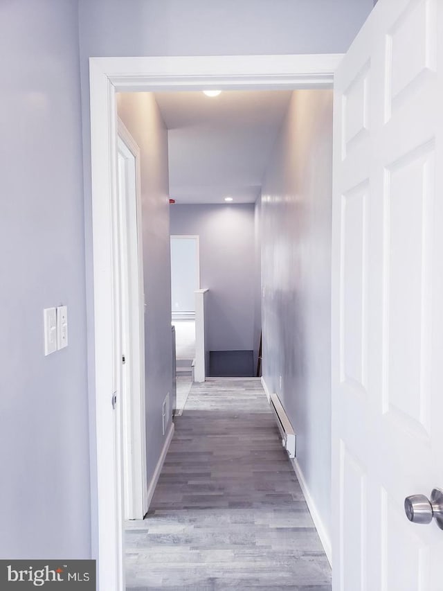 hallway featuring a baseboard heating unit and light hardwood / wood-style flooring