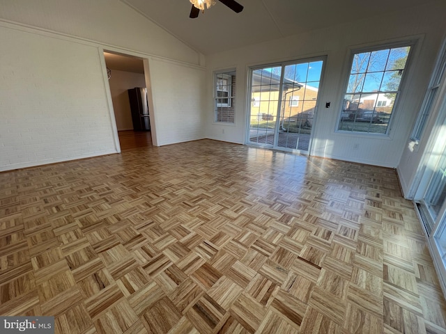 spare room featuring brick wall, ceiling fan, and high vaulted ceiling