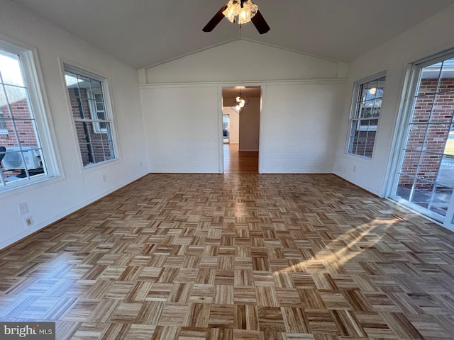 unfurnished sunroom featuring a ceiling fan, a healthy amount of sunlight, and vaulted ceiling