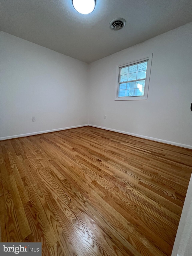 unfurnished room with light wood-type flooring, baseboards, and visible vents