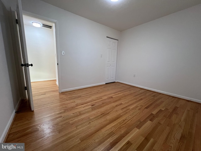 unfurnished bedroom with light wood-type flooring, visible vents, and baseboards