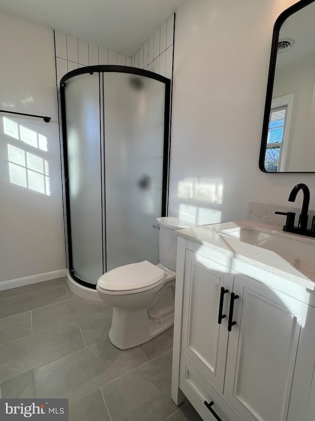 bathroom with vanity, toilet, a shower with shower door, and tile patterned flooring