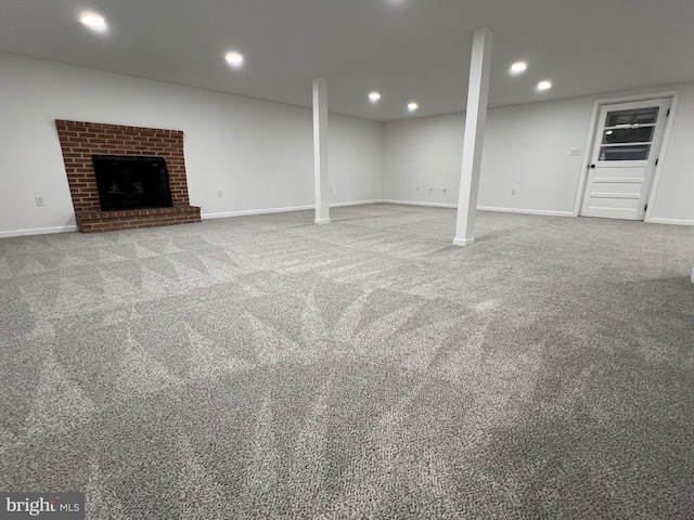 basement with carpet floors and a brick fireplace