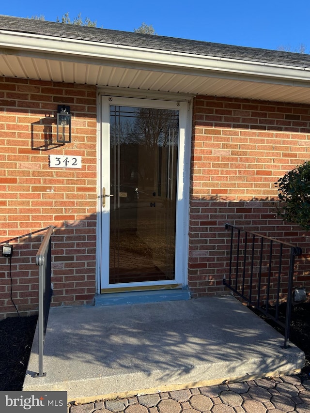 view of exterior entry featuring brick siding