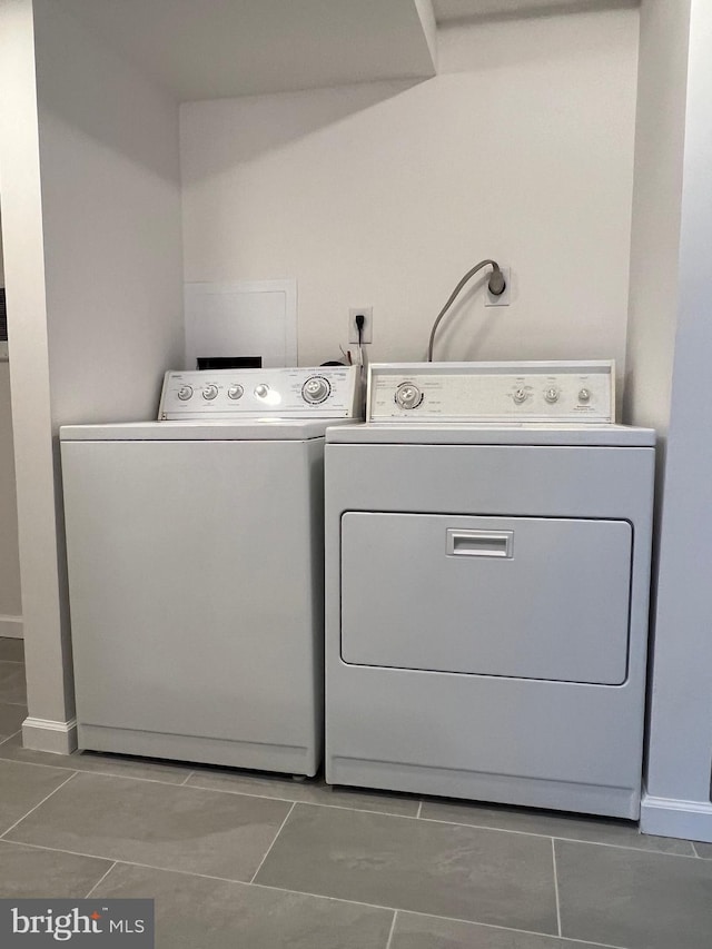 laundry room with laundry area, washing machine and dryer, and baseboards