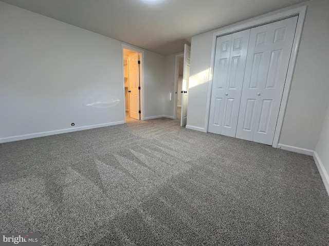 unfurnished bedroom with a closet, carpet flooring, and baseboards