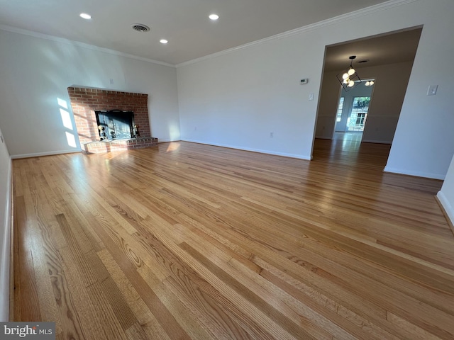 unfurnished living room with crown molding, a fireplace, and light hardwood / wood-style flooring