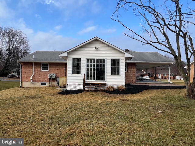 rear view of property featuring entry steps, brick siding, and a lawn