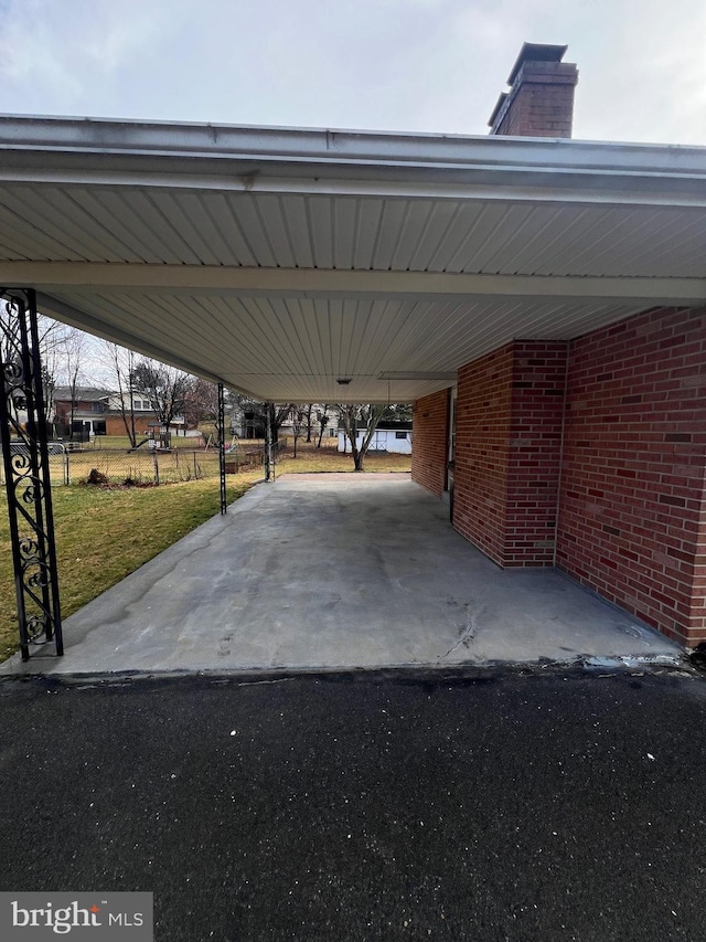 view of parking / parking lot featuring a carport and a yard