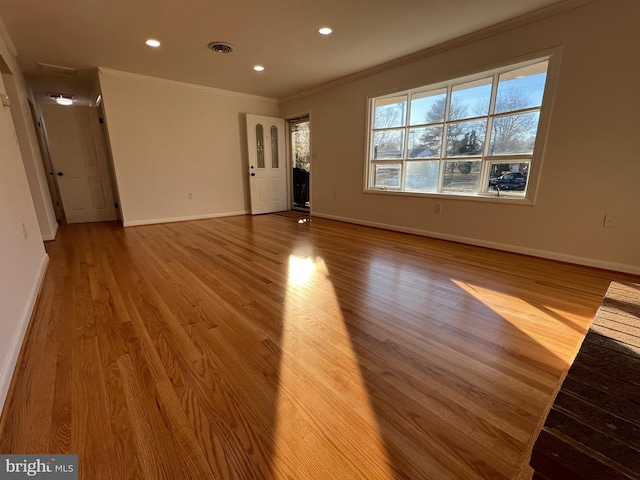 unfurnished living room featuring baseboards, visible vents, ornamental molding, wood finished floors, and recessed lighting