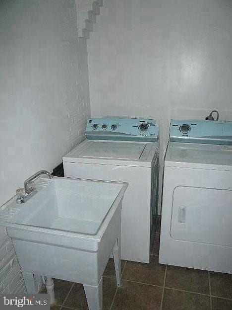 laundry area with separate washer and dryer, sink, and dark tile patterned floors