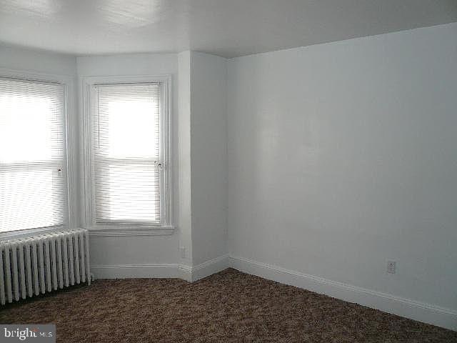 carpeted spare room with radiator