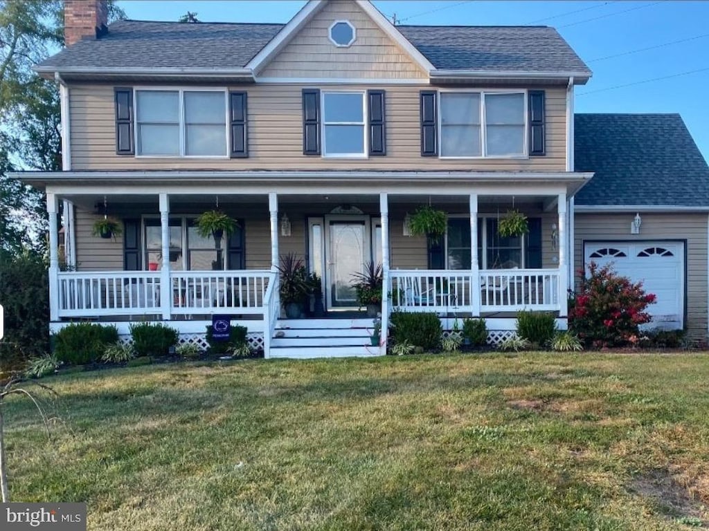 view of front of house featuring a garage, a shingled roof, a chimney, a porch, and a front yard