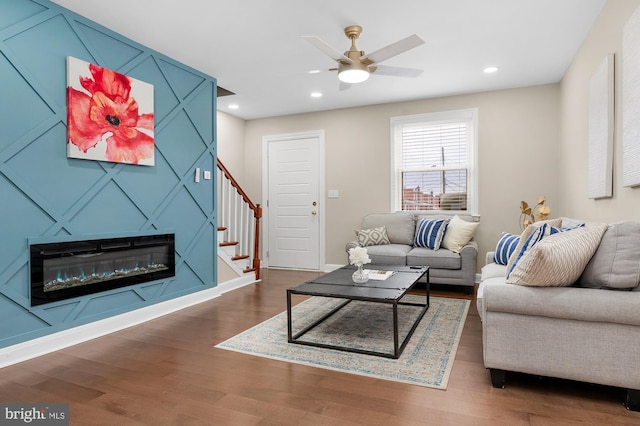 living room featuring dark wood-type flooring and ceiling fan