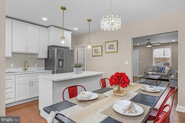 dining room featuring ceiling fan, light hardwood / wood-style floors, and sink