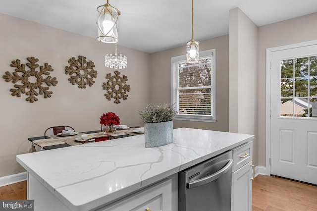 kitchen featuring hanging light fixtures, plenty of natural light, dishwasher, and white cabinets