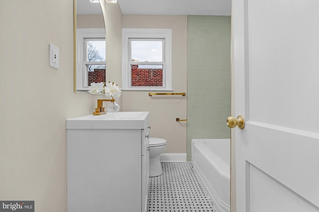 bathroom featuring vanity, toilet, and a tub